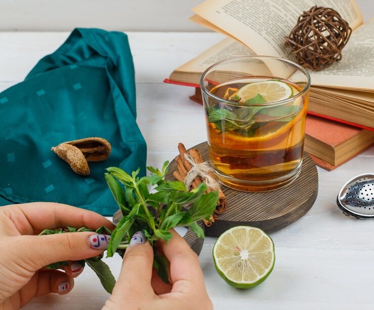 set-books-lemon-mint-green-scarf-herbal-tea-cinnamon-wooden-board_176474-28080